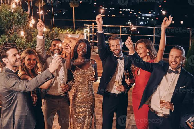 Grupo bem vestido brindando e comemorando com estrelinhas numa festa à noite